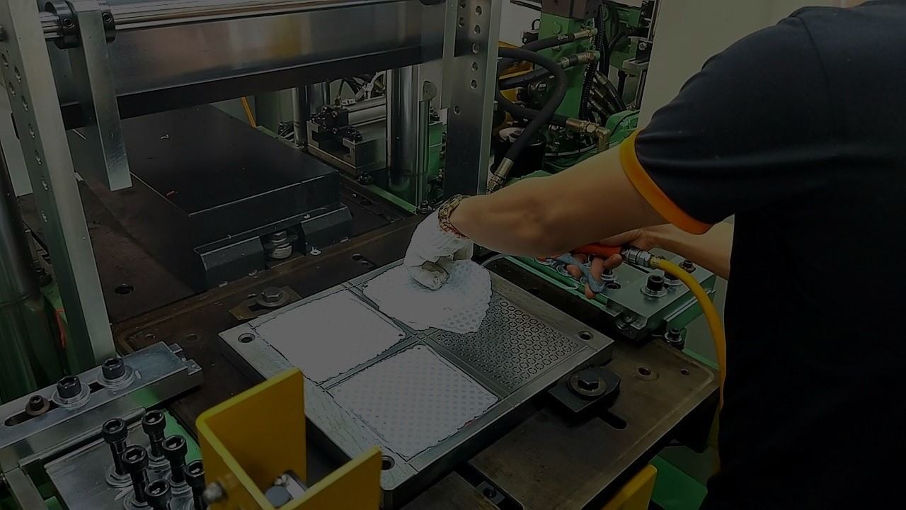 Skilled worker operating a hydraulic rubber compression molding press at Vina Rubber factory